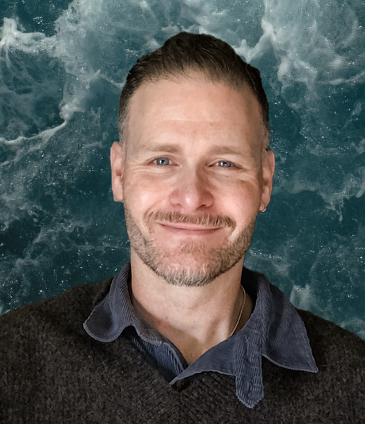 Sam Pollard - Portrait photo in front of a sea background.